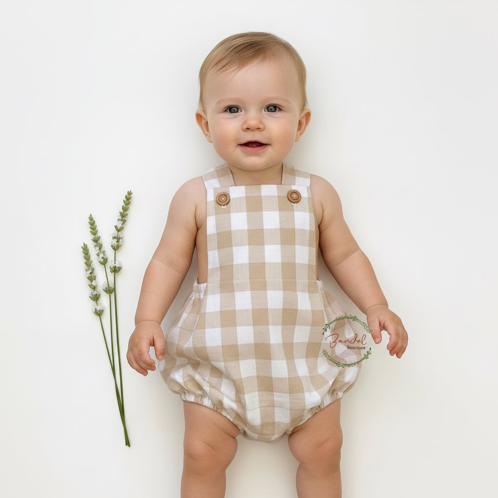 Plaid baby romper with button details on a white background
