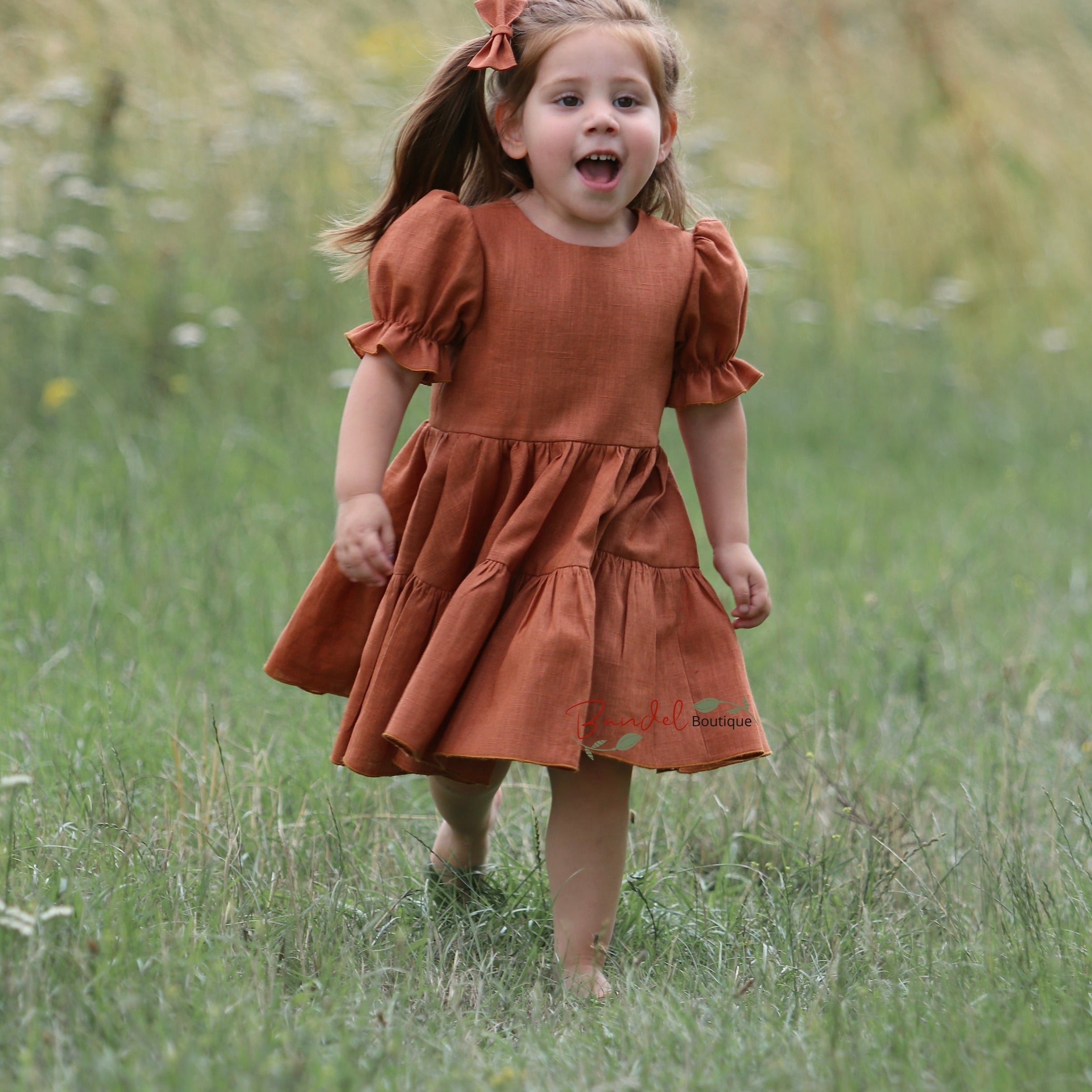 Linen Rust Dress is the perfect special-occasion look for your little flower girl. Made of breathable linen and featuring a square neckline, flutter sleeves, and a playful ruffle hem, this design is both comfortable and fashionable. The back of the dress has a double row of rustic wooden buttons for an elegant finishing touch.