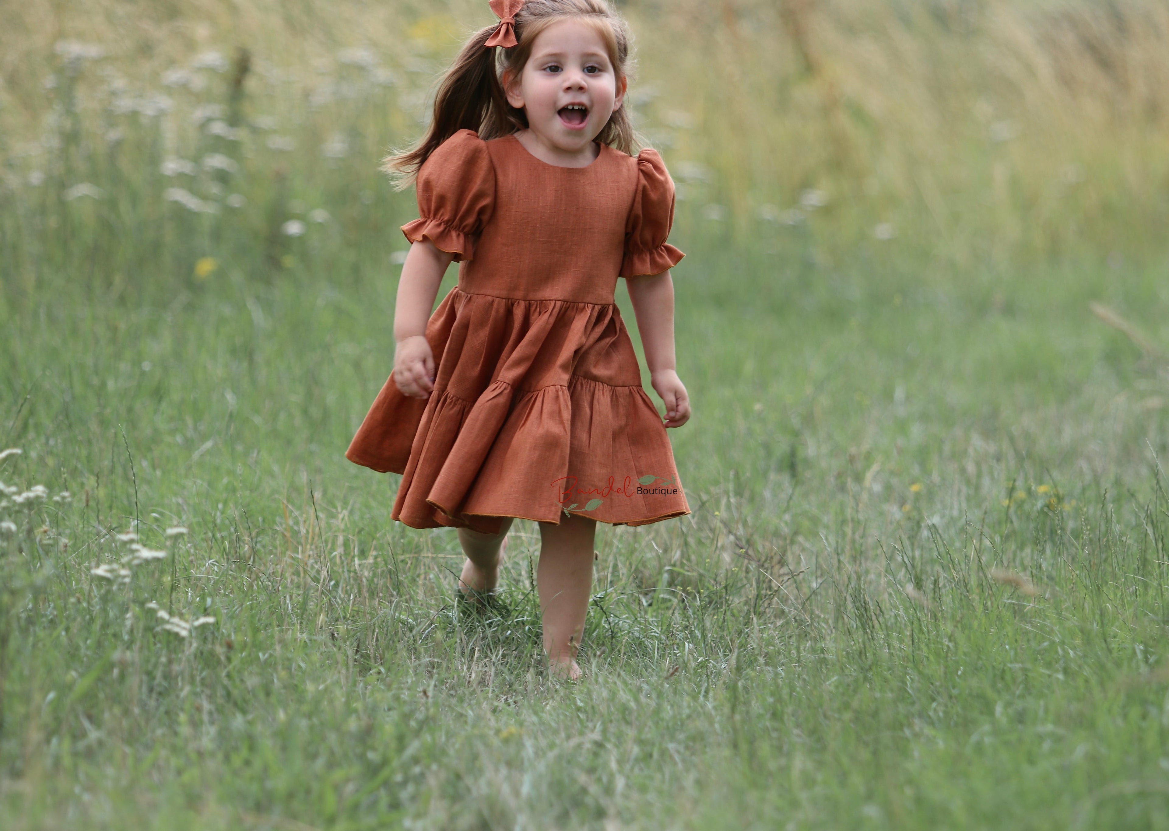 Linen Rust Dress is the perfect special-occasion look for your little flower girl. Made of breathable linen and featuring a square neckline, flutter sleeves, and a playful ruffle hem, this design is both comfortable and fashionable. The back of the dress has a double row of rustic wooden buttons for an elegant finishing touch.
