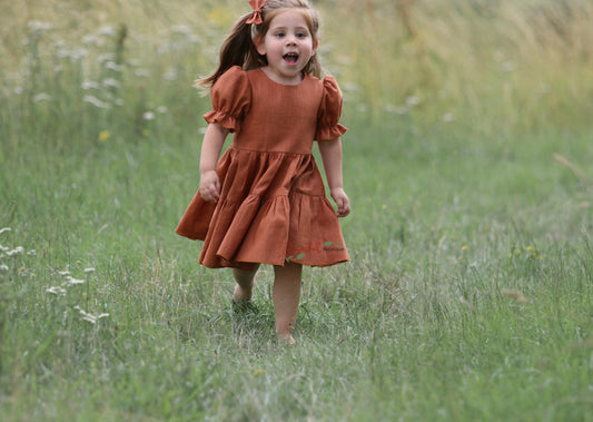 Linen Rust Dress is the perfect special-occasion look for your little flower girl. Made of breathable linen and featuring a square neckline, flutter sleeves, and a playful ruffle hem, this design is both comfortable and fashionable. The back of the dress has a double row of rustic wooden buttons for an elegant finishing touch.