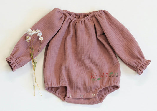 Handmade old- rose minimalist newborn baby romper with long sleeves, made from breathable and soft double gauze organic fabric. Features elasticized openings and crotch snaps for easy dressing and maximum comfort. 