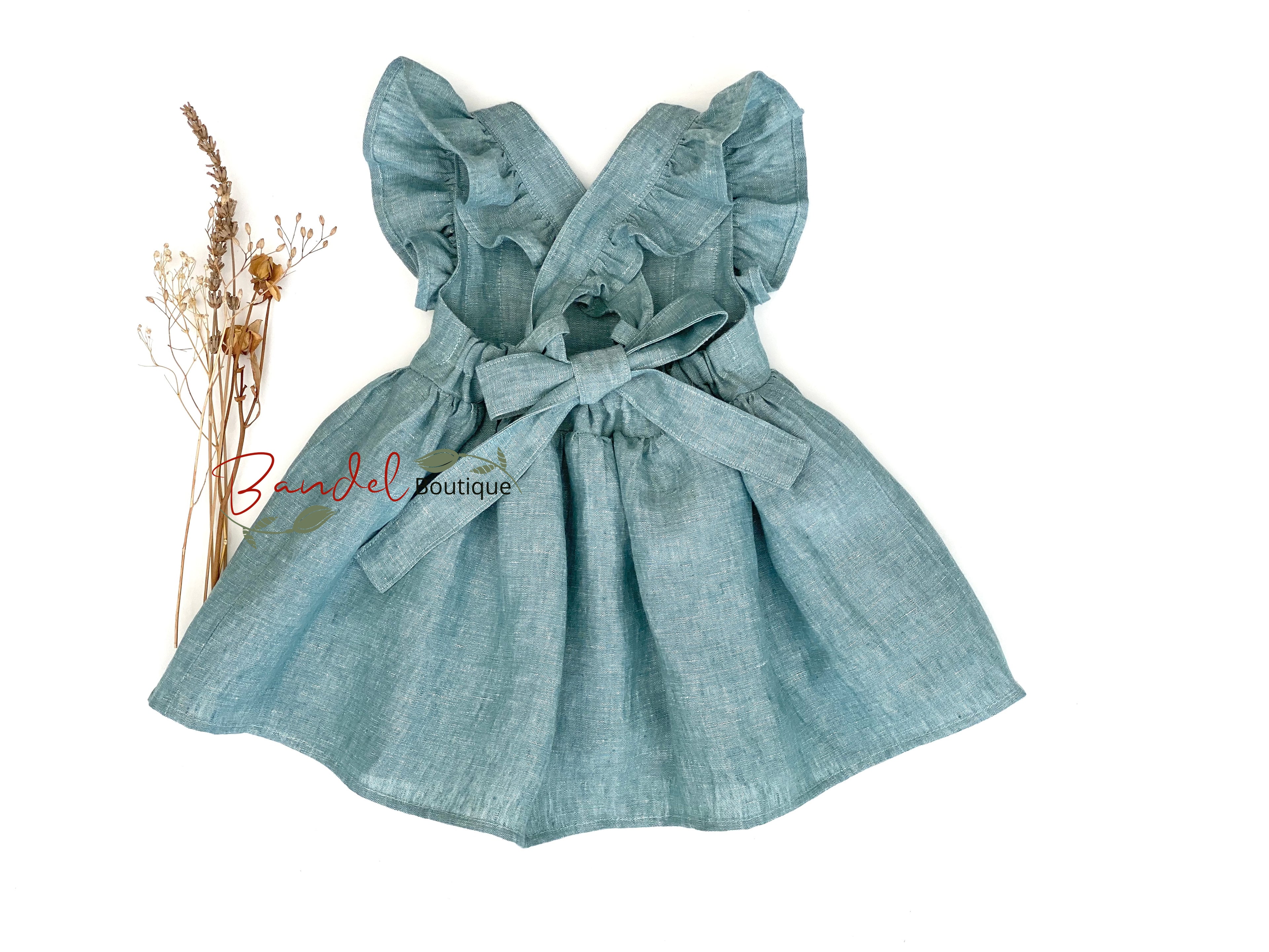 Light blue dress with ruffled sleeves on a white background, featuring 'Bendel Boutique' branding.