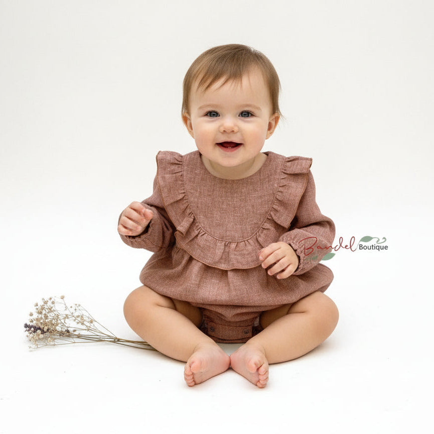 Baby wearing a brown ruffled outfit on a white background