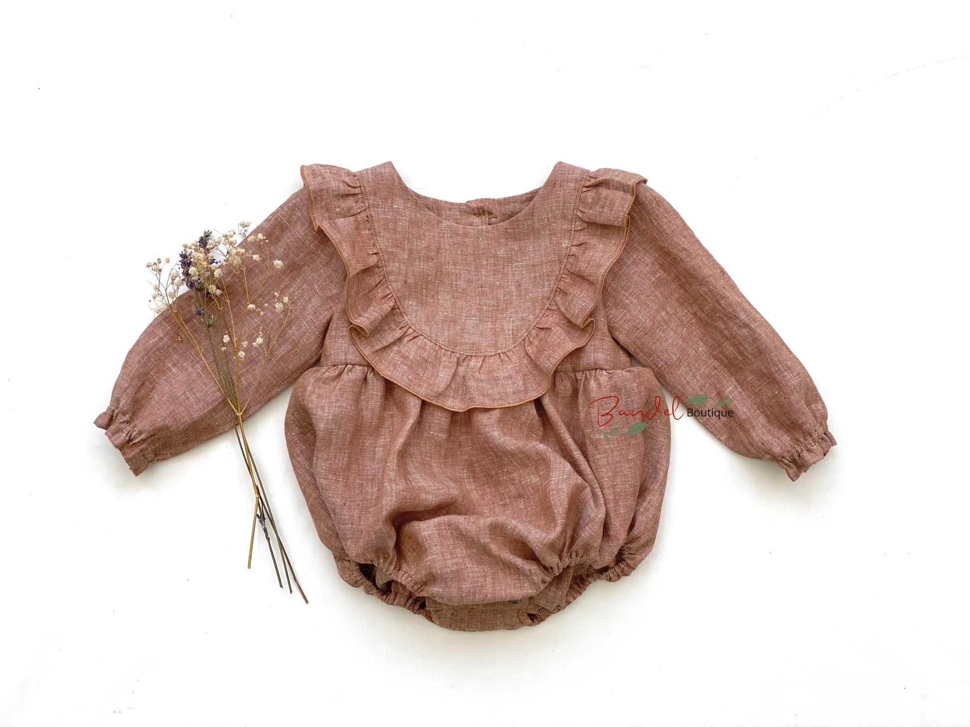 Brown baby romper with ruffled details on a white background