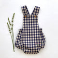 Adorable blue gingham baby romper featuring adjustable straps and rustic wooden buttons. 