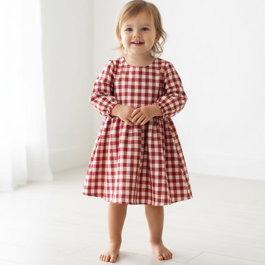 Child wearing a red and white checkered dress on a white background