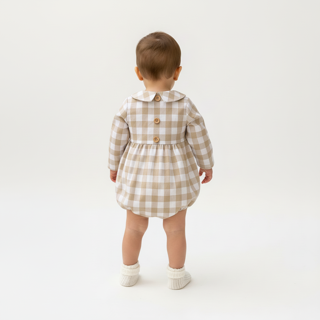 Baby wearing a checkered playsuit on a white background