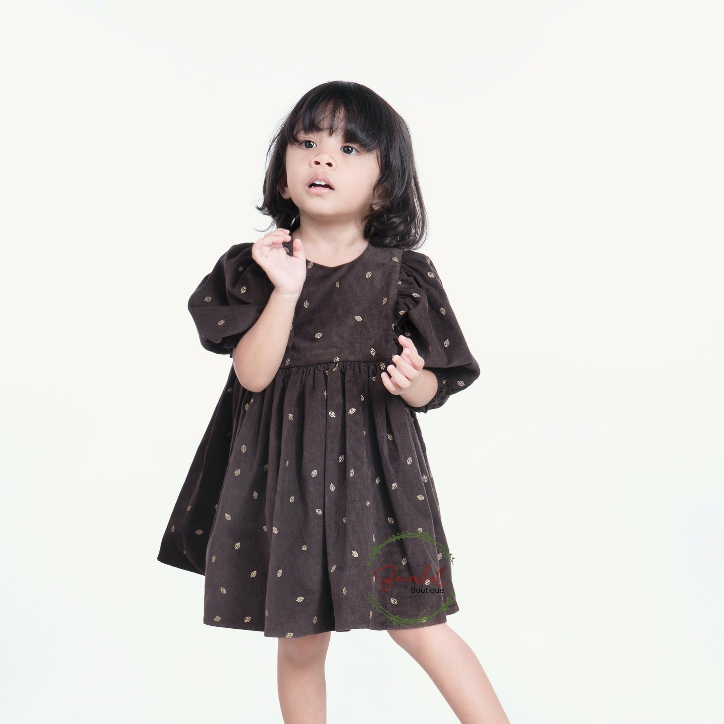 3/4 Sleeves Corduroy Girl Dress Crafted with a luxurious corduroy fabric featuring gold leafs prints and classic styling, this whimsical dress is finished with a ruffled hem, 3/4 length sleeves, and a wooden button closure at the back bodice.