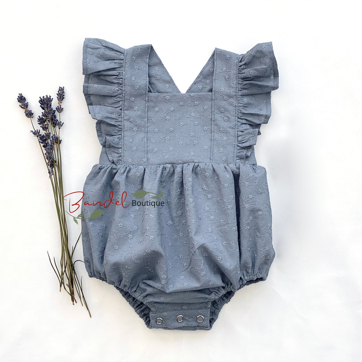 Blue baby romper with ruffled straps on a white background