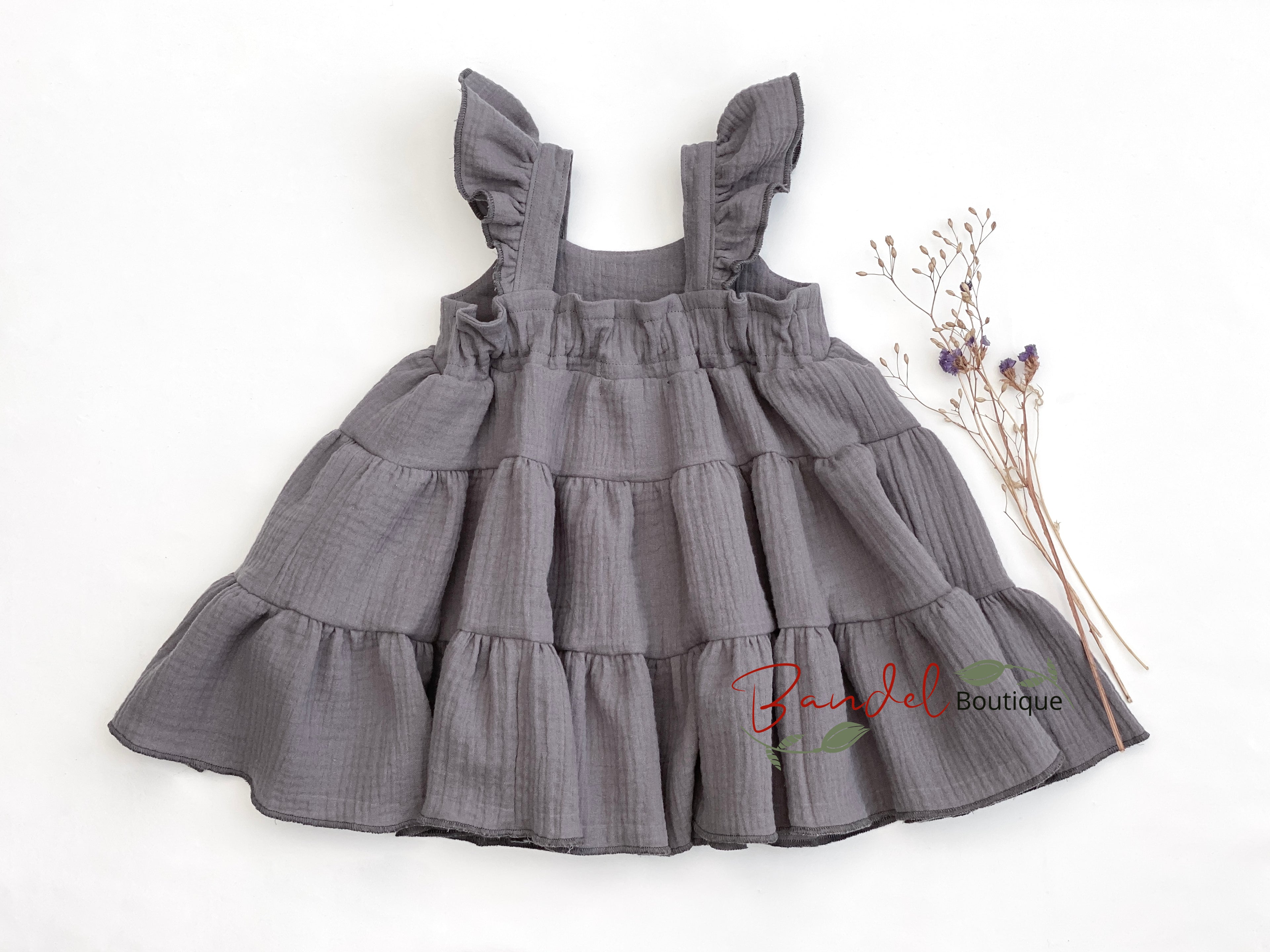 Gray tiered dress on a white background with 'Bundel Boutique' branding.