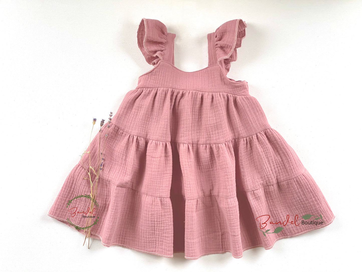 Pink checkered dress with ruffled straps on a white background