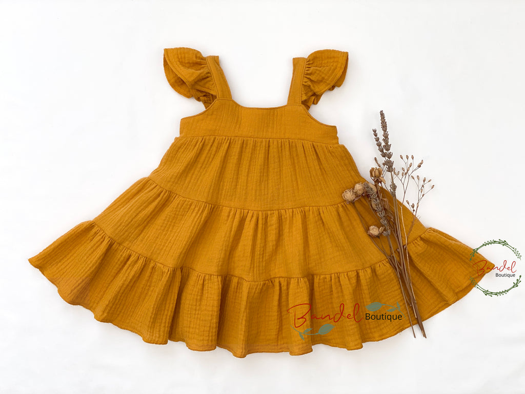 Mustard yellow dress with ruffled straps on a white background