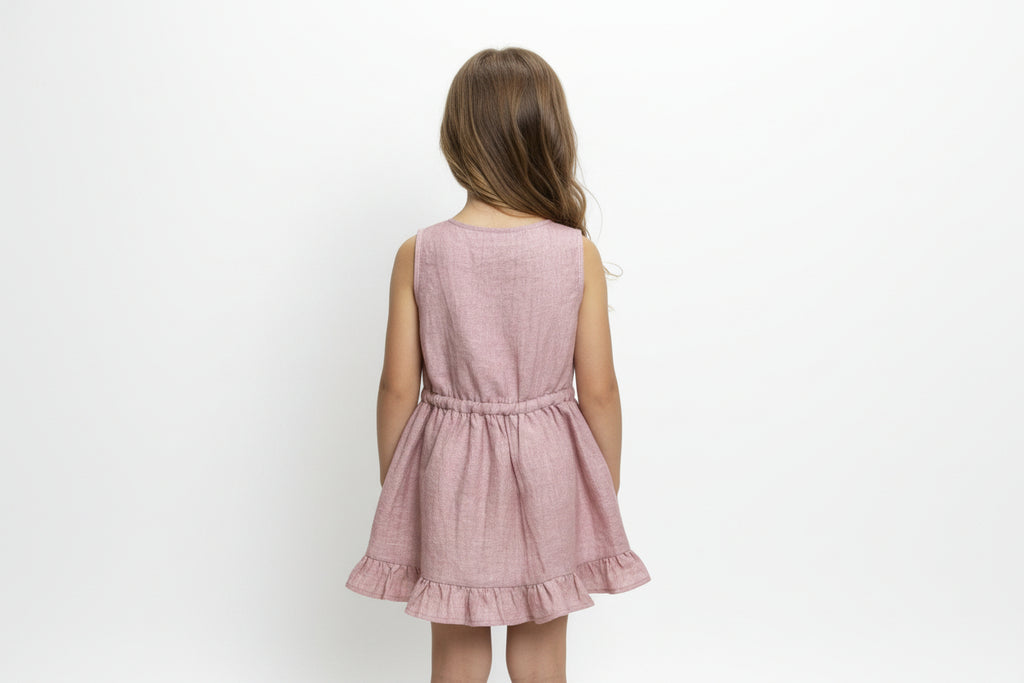 Pink dress with ruffled hem on a wooden hanger against a white background