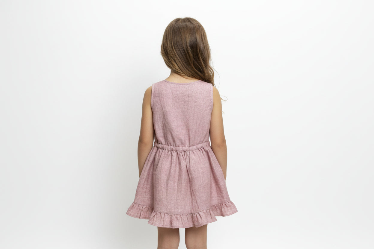 Pink dress with ruffled hem on a wooden hanger against a white background