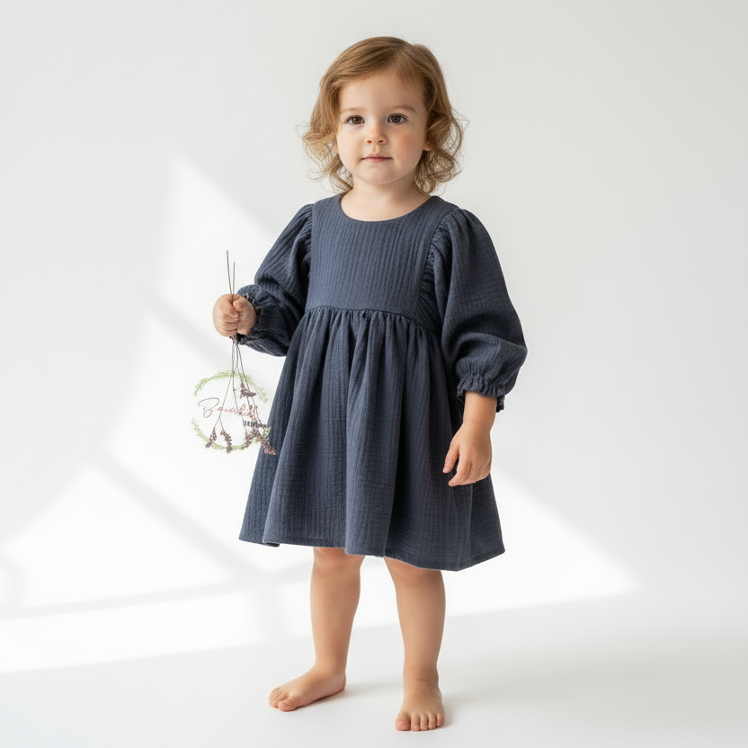 Young child wearing a dark blue dress on a white background
