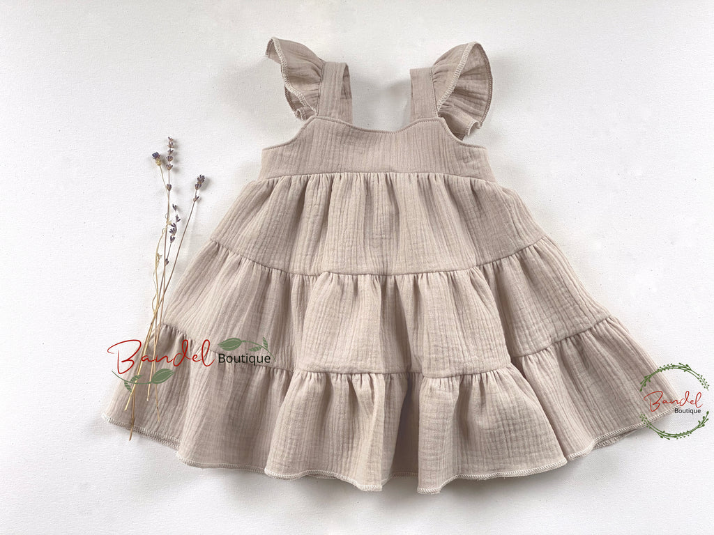 Beige tiered dress on a white background with 'Bonafide Boutique' branding.