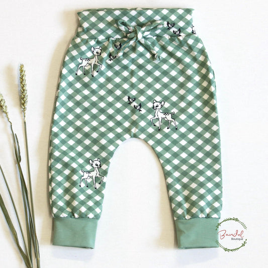 Deer Baby Leggings With Drawcord are made of premium jersey cotton, adorned with a check green deer print, and feature a wide waist band and drawstring for adjustable comfort. The cuffed ankles add to the secure fit, ensuring your little one can move freely and fashionably.
